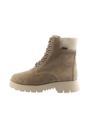 Bottine en suede taupe à lacets avec un col rembourré beige, semelle épaisse et étiquette Gore-Tex sur le côté extérieur.