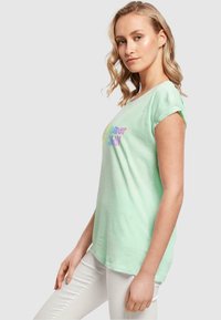 Mintgrøn kortærmet t-shirt med "Summer & Chill" trykt i flerfarvet tekst; blødt stof, afslappet pasform, rund halsudskæring.