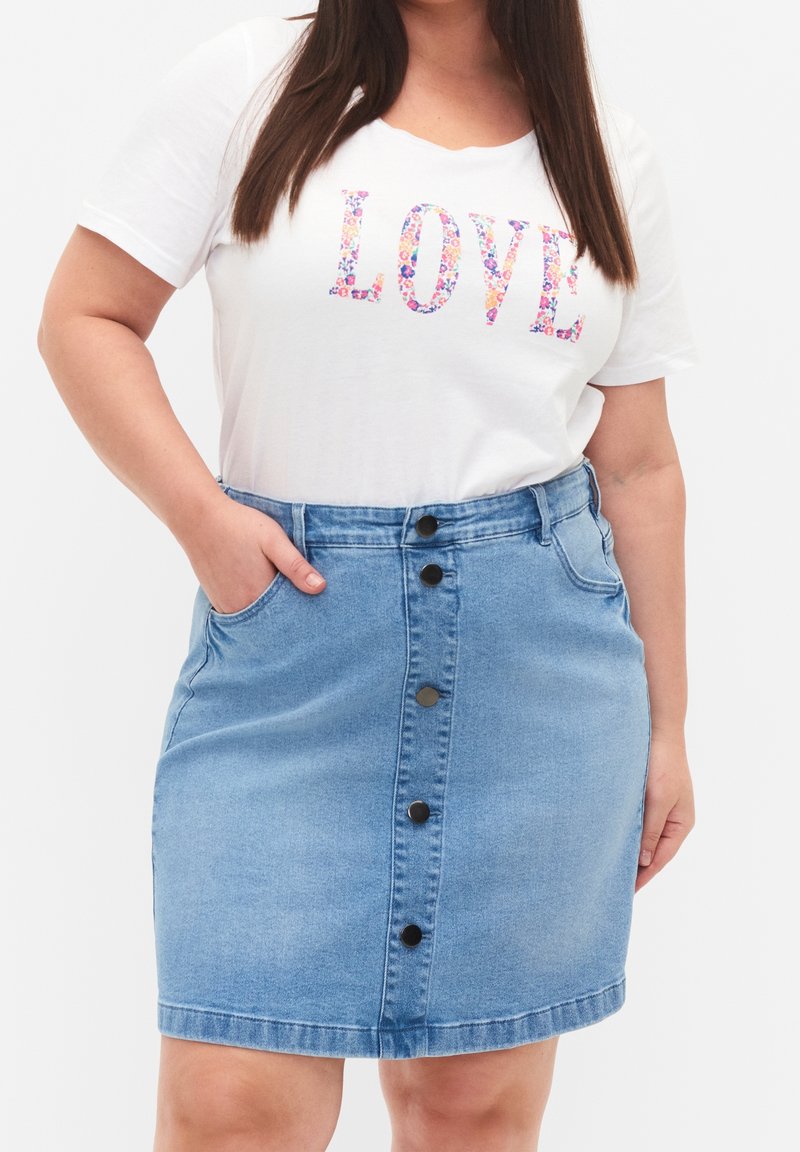 Jeanskjol med hög midja, ljusblå färg, framficka och svarta knappar. Matchad med en vit t-shirt med färgglada blommiga bokstäver.