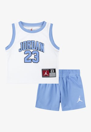 Wit mouwloos basketbalshirt met blauwe bies en de tekst "JORDAN 23", gecombineerd met blauwe shorts met een wit Jumpman-logo.