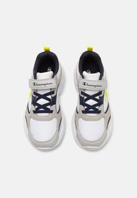 Scarpe da ginnastica bianche e grigie con accenti blu navy, materiale testurizzato, logo prominente e un dettaglio giallo. Presentano una fascia velcro e lacci.