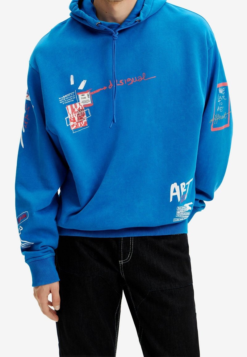 Modrá mikina s kapucí s grafickými potisky v červené a bílé barvě. Má kapuci se stahovací šňůrkou, žebrované manžety a různé textové a vzorové detaily na rukávech.