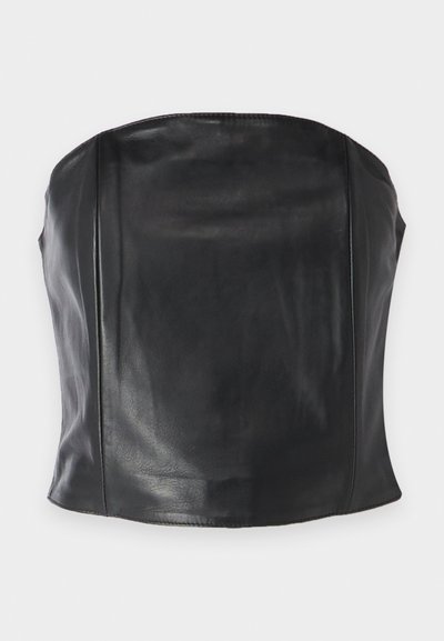 Must suletükk mustast nahast, millel on napp disain, sile tekstuur ning peened õmblused kehal, et saavutada kohandatud välimus.