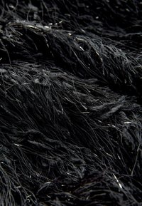 Black textured fabric featuring long, fluffy strands and subtle metallic accents, creating a layered, soft appearance.