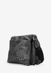Bolso cruzado gris hecho de material texturizado con acentos de tachuelas metálicas y un patrón de diseño circular en el frente; correa ajustable.