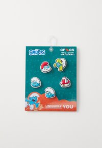 Smurfs-thema Jibbitz charms met blauwe karakters met onderscheidende gezichtskenmerken, hoeden en een rode paddenstoel op een turkooizen verpakkingsachtergrond.