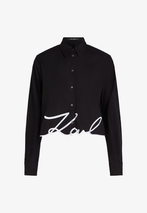 Fekete, cropped fazonú ing hosszú ujjal, gombos elülső résszel és nagy, fehér hímzett "Karl" logóval az alján. Puha, sima anyag.