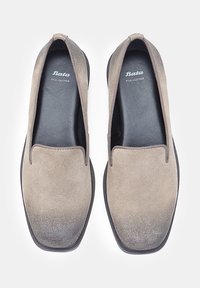Brown suede slip-on shoes with a smooth leather insole, rounded toe, and elastic accents for fit. Sole has a textured finish.