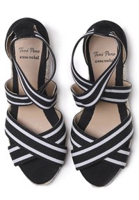 Mustad espadrilid mustade ja valgete triipudega kudumistroppidega. Omab loomulikku juto alust ja sujuvat sisepinna vooderdust.