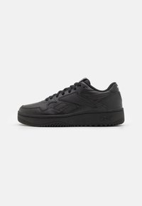 Black leather sneaker with a round toe, lace-up front, textured detailing, and a thick black rubber sole. Side logo visible.