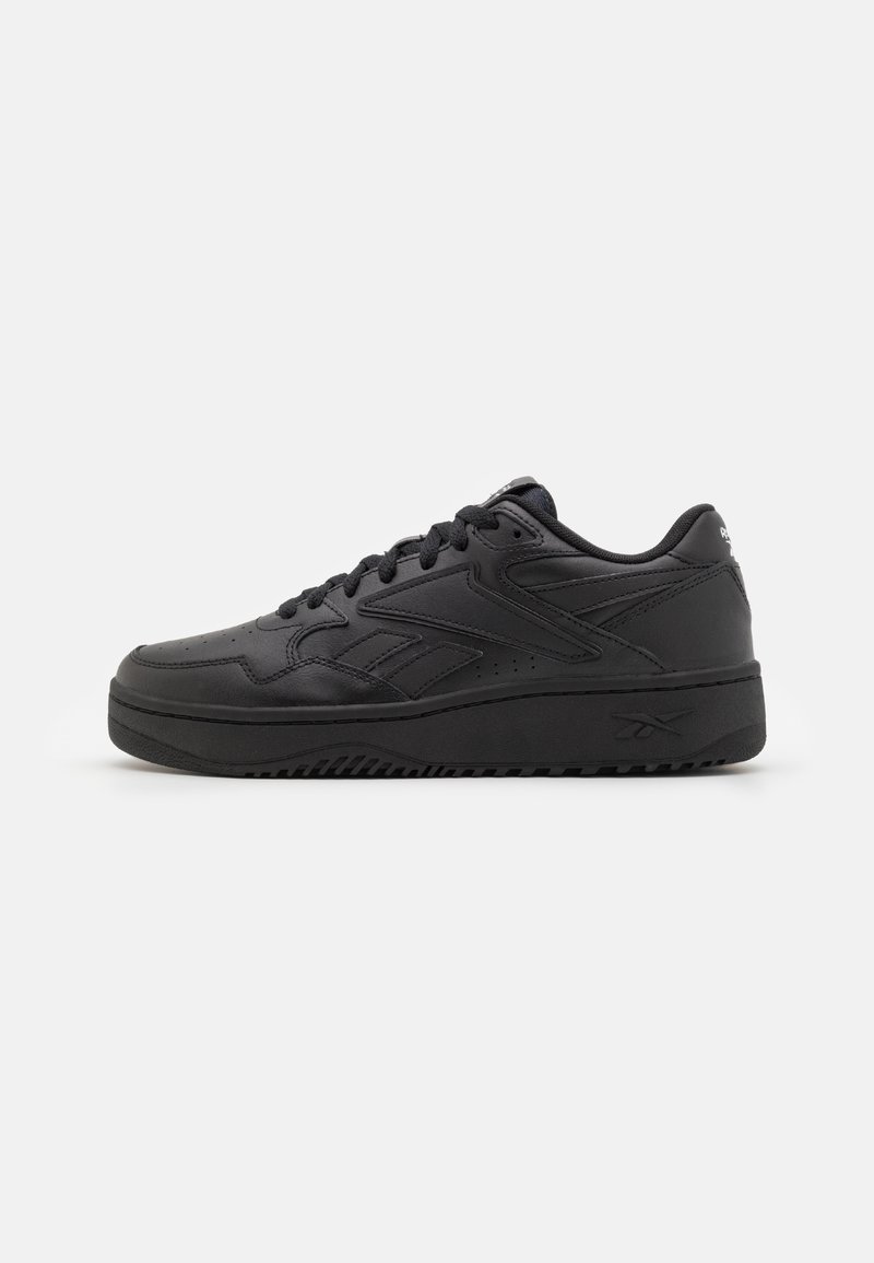 Black leather sneaker with a round toe, lace-up front, textured detailing, and a thick black rubber sole. Side logo visible.