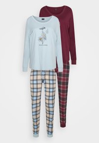 Twee sets loungewear: een lichtblauwe longsleeve top met bloemenprint en een bordeauxrode top. Gecombineerd met beige en blauw geruite broek en een donker geruite broek.