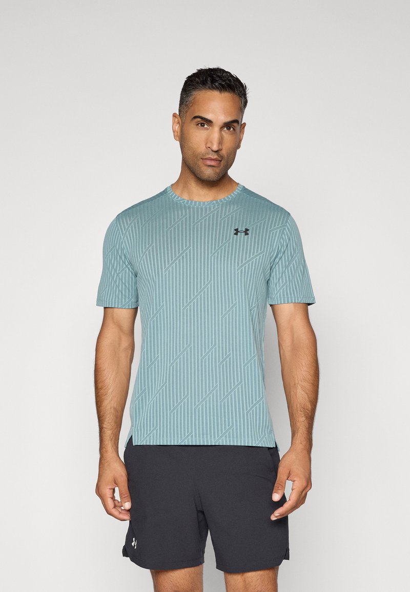 Camiseta atlética de color azul claro con rayas verticales texturizadas y un cuello redondo, que presenta un pequeño logo negro en el lado izquierdo del pecho.