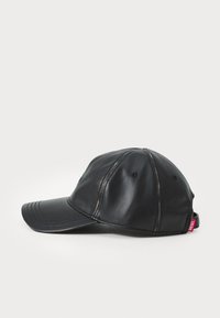 Fekete bőr baseball sapka ívelt napellenzővel, varrott részletekkel és fémbetétű szellőzőkkel; az oldalon egy kis márkás címke található.