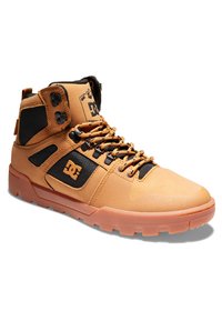 Visoke skate tenisice u boji tan s crnim detaljima, izrađene od teksturiranog sintetičkog materijala, s ojačanim vrhom i robusnom gumenom potplatom. Imaju jarke vezice i brendiranje.