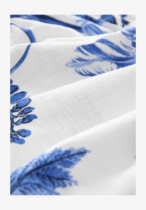 Bílá látka s modrými květinovými vzory, obsahující detailní listy a květy, vykazující jemný, texturovaný vzhled.