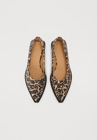 Bailarinas de punta afilada con estampado de leopardo, confeccionadas en cuero suave con un fondo beige, detalles en negro y un diseño de lado abierto.