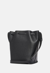 Svart läder bucket bag med en strukturerad yta, justerbar axelrem och dragsnörning upptill. Kompakt och väldefinierad design.