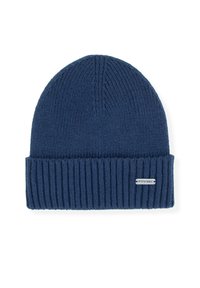 Námořnicky modrá pletená čepice s žebrovaným lemem, měkkou texturou a stříbrnou logovou štítkem na boku. Bezešvá koruna s vertikálním pleteným vzorem.