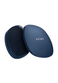 Zwei dunkelblaue ovale Silikon-Gesichtsreinigungsbürsten, eine zeigt weiche Borsten, die andere mit "GESKE" Aufdruck auf der glatten Rückseite.