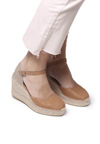 Béžové plátěné espadrilky na wedges s kulatou špičkou, řemínkem kolem kotníku a spletenou juty v mezipodešvi, s texturovaným povrchem a mírně zvýšeným podpatkem.