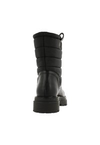 Botín negro que presenta un upper de nylon acolchado, tacón de cuero texturizado, lengüeta y suela de goma con surcos.