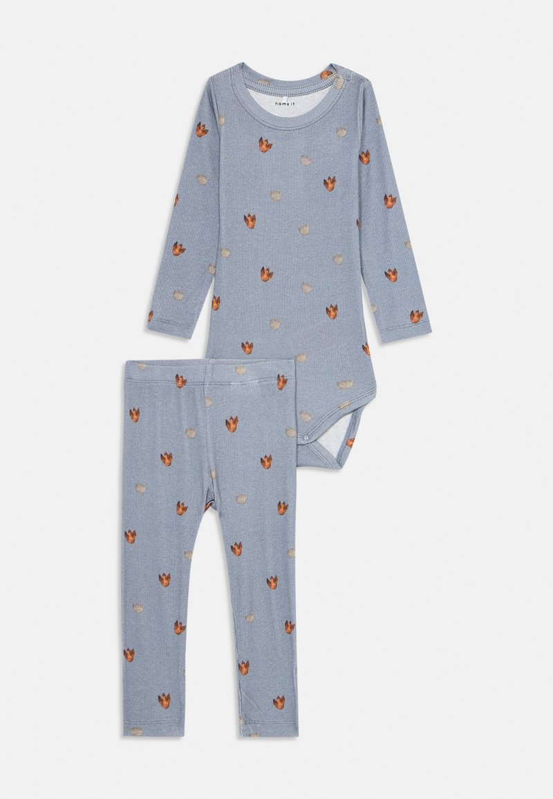 Blauer, gerippter Langarm-Body und Hose für Kleinkinder im Set, mit einem Muster aus orangefarbenen und beigen Dinosaurierfußabdrücken.