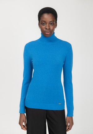Heller blauer Rollkragenpullover aus weichem Stoff, mit langen Ärmeln und geripptem Saum, getragen mit schwarzen Hosen.