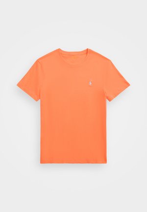 T-shirt à manches courtes en coton orange vif avec un col rond et un petit logo blanc sur la poitrine gauche. Texture lisse et coupe classique.