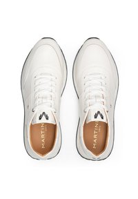 Zapatillas de cuero blancas con puntera redonda, cordones en la parte delantera y acentos texturizados. Presentan un forro interior marrón y suela negra. La marca es visible en la lengua.