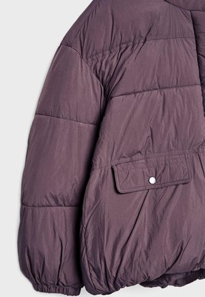 Giacca imbottita viola con superficie testurizzata, polsini elasticizzati e tasca a patta con chiusura a pressione. Presenta una vestibilità rilassata e oversize.