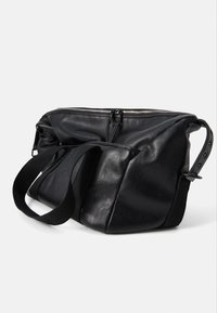 Black leather crossbody bag with a zip closure, adjustable strap, and soft texture. Features a streamlined, angular design.