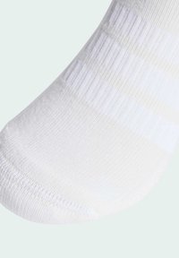 Calcetín blanco con una textura suave y un sutil patrón acanalado, con una puntera redondeada y un puño ligeramente elástico.