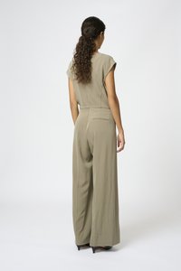 Olive green jumpsuit with fitted bodice and wide-legged pants, featuring cap sleeves and a back pocket. Smooth, satin-like texture.