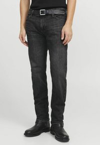 Svarta denimjeans med slim fit, med en klassisk femfickdesign, bälteshällor och en subtil tvätt. Matchade med ett svart läderbälte och stövlar.