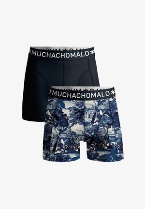 Conjunto de bóxers que incluye un par negro liso y otro azul con patrones de mariposas y paisajes, ambos con cintura elástica "MUCHACHO MALO".