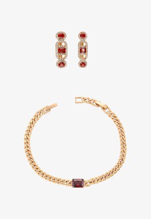Kultasävyinen ketjurannekoru, jossa keskellä suorakaiteen muotoinen punainen kivi, ja siihen sopivat korvakorut, joissa on punaiset kivet kultasävyisissä kehyksissä.
