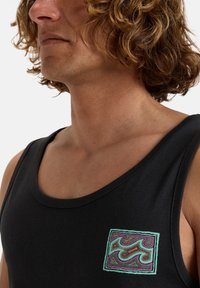 Canotta nera con toppe ricamate multicolore e motivi a spirale. Tessuto morbido, scollo rotondo, ampie aperture per le braccia, progettata per un abbigliamento casual.