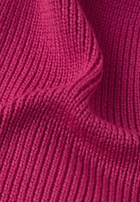 Dziana tkanina w żywym różowym kolorze, z wyraźnym wzorem prążków. Miękki materiał prezentuje wyraźne szwy i gładkie wykończenie.