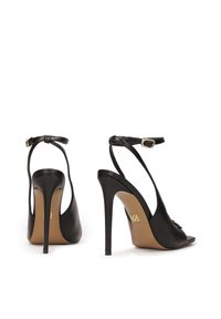 Zwarte leren hoge hak sandalen met een slank ontwerp, open teen en enkelband; voorzien van een decoratieve gespaccent op de band.