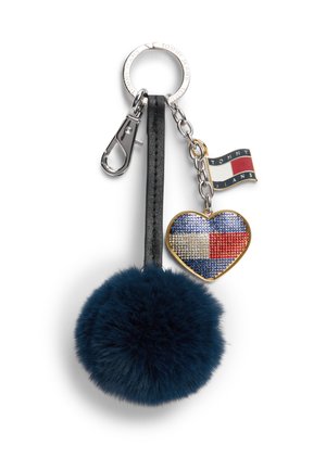 Porte-clés avec un pompon duveteux bleu marine, un cœur bordé d'or avec un motif en strass bleu, blanc et rouge, et un petit pendentif drapeau avec "Tommy Jeans."