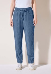 Pantaloni azzurri chiari, di taglio morbido e comodo, con elastico in vita, chiusura con cordino e gamba affusolata, realizzati in un tessuto morbido e traspirante.