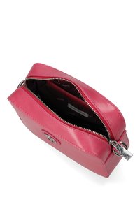 Borsa a mano in pelle rosa con chiusura a zip, forma rettangolare, hardware in argento e fodera in tessuto a trama. Dettaglio del logo ben visibile sulla parte anteriore.