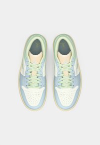 Ζευγάρι σνίκερς σε παστέλ αποχρώσεις με ανοιχτό πράσινα κορδόνια, πάνελ σε μπλε και κρέμα απόχρωση, και εμφανές λογότυπο Jumpman μέσα στην περιοχή της φτέρνας.