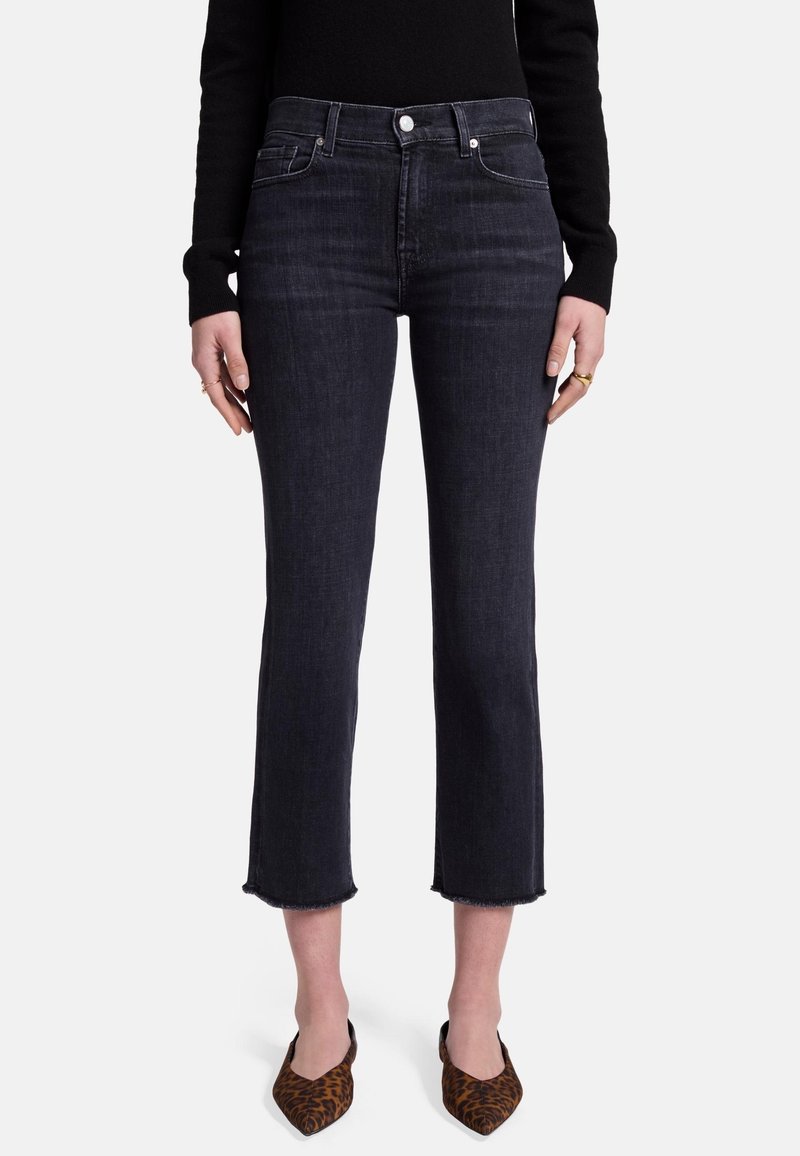 Jean taille haute en denim indigo foncé, avec une longueur croppée aux chevilles, un ourlet brut et une légère élasticité. Présente un style classique à cinq poches.