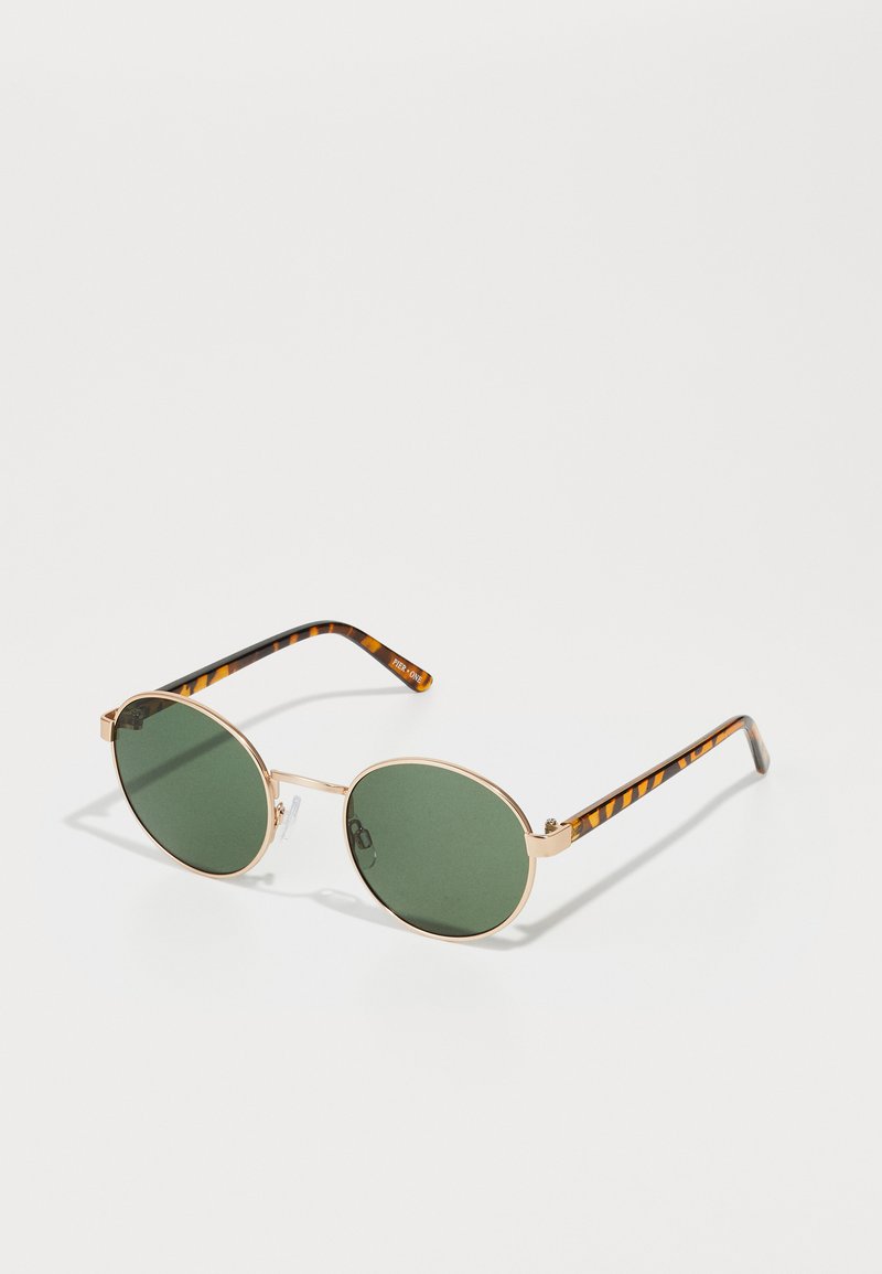 Óculos de sol redondos com lentes verdes, armação de metal dourado e hastes com padrão de tartaruga. Almofadas de nariz transparentes para conforto.