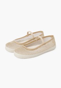 Bailarinas de lona beige con parte superior de malla, puntera redonda y correas elásticas; suelas de goma blanca con patrón texturizado para mayor agarre.