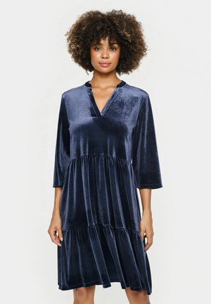 Navyblaues Samtkleid mit V-Ausschnitt, Dreiviertelärmeln und gestuftem Rockdesign; glatte Textur und subtiler Glanz.