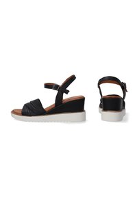 Zwarte leren wedge sandalen met een gestructureerde voorband, verstelbare enkelriem en witte rubberen zool met een zigzagpatroon.