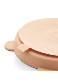 Silikona šķīvis maigi rozā krāsā, apaļas formas ar paceltu malu un divām mazām ausīm. Aprīkots ar cilpu ērtākai satveršanai. Teksturēta virsma.